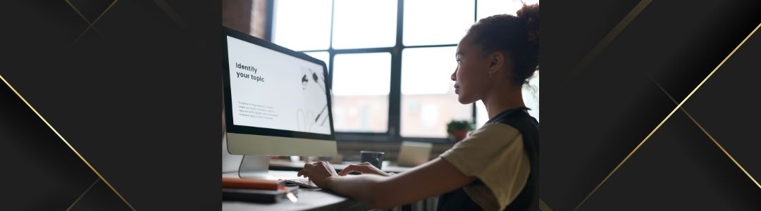 Image d'illustration d'un homme noir en train de travailler avec un ordinateur bureau de 27 pouces. Il doit y avoir des graphiques statistiques sur l'écran de l'ordinateur.